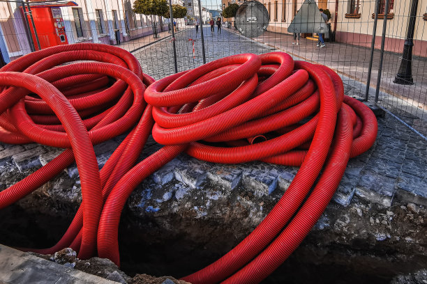 红色塑料管用于街道上的地下电缆保护图片下载