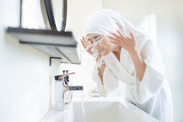 在浴室洗脸的亚洲女人图片下载