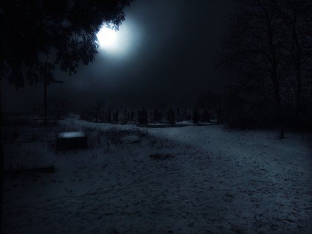 晚上神秘的废弃墓地。在有雾的冬天，大明月在夜晚的墓地上空。图片下载