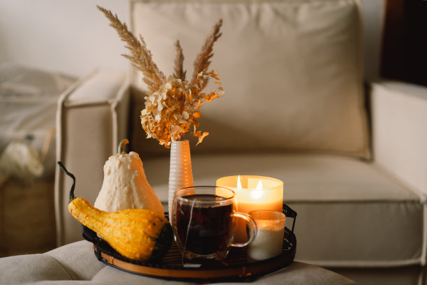 客厅家居室内的静物细节。南瓜和一杯茶，托盘上放着蜡烛图片下载