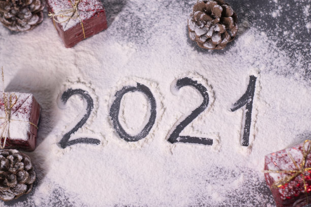 圣诞装饰品，装饰元素在雪。红色的礼物和锥形物。在雪地里用手指画出“2021”。圣诞节的心情。断然的照片图片下载