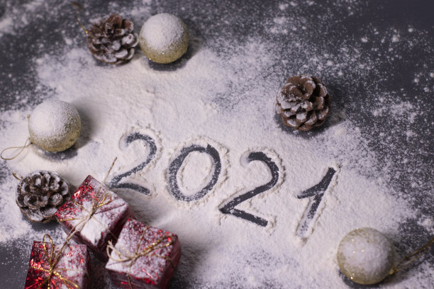 圣诞装饰品，装饰元素在雪。金色的球和锥形。在雪地里用手指画出“2021”。圣诞节的心情。断然的照片图片下载