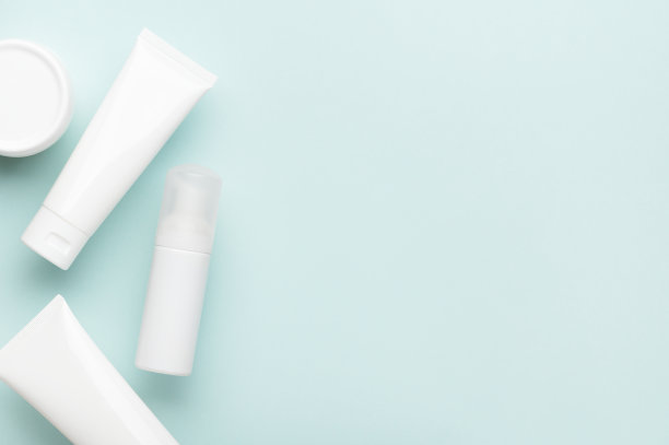 白色塑料罐和管与化妆品美容产品卫生上绿松石背景。俯视图面霜，喷雾和身体乳液。为女性护肤品设置平躺与复印空间图片下载