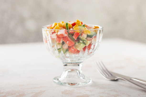 蟹肉棒、黄瓜、鸡蛋和玉米沙拉。俄罗斯的节日食品图片下载