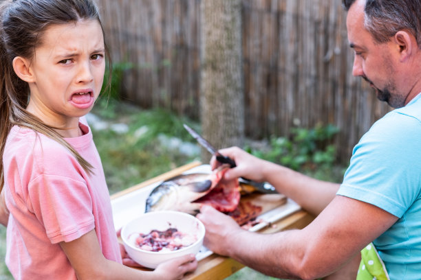 爸爸切鱼时女孩的表情图片下载