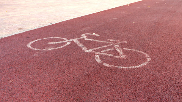 红色自行车道上的白色自行车标志图片下载