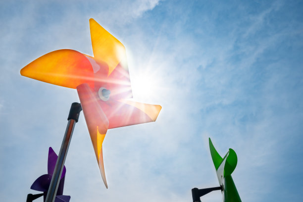 一个黄色的风车在晴朗的阳光下旋转。图片下载