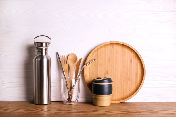 环保设置竹餐具，可重复使用的水瓶和杯子在木制背景。图片下载