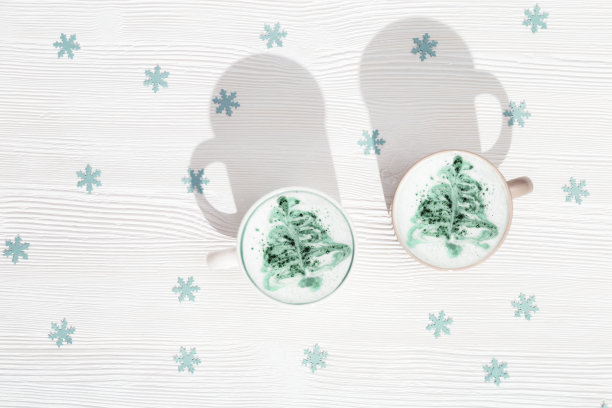 冬季卡布奇诺艺术与新年树的顶视图。假日早晨的热咖啡。在咖啡店购物。图片下载