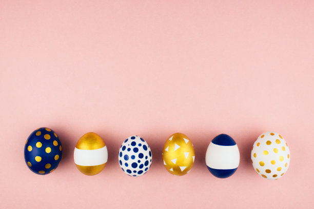 现代时尚的金色和蓝色的春天复活节彩蛋装饰平铺在彩色的粉红色背景顶视图与复制空间。复活节快乐庆祝概念。网络旗帜模板。股票的照片。图片下载