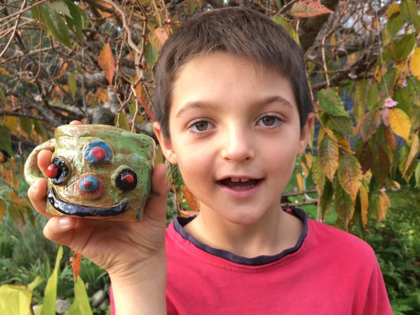 孩子拿着他的陶瓷杯图片下载