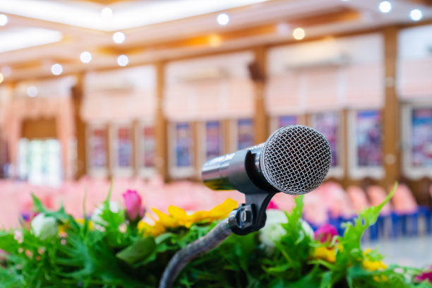 演讲厅麦克风对演讲进行抽象模糊处理，演讲厅灯光用于展示活动背景。麦克风是将声音转换成电信号的传感器。图片下载