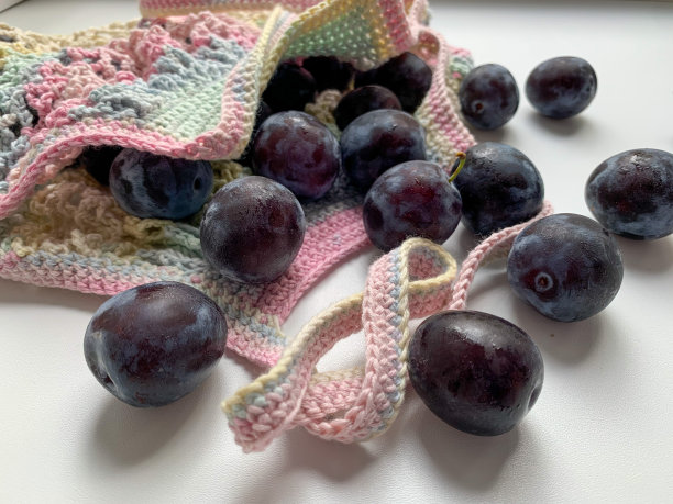 新鲜的梅子装在彩色的网袋里，背景是白色的。从上面的照片。“零浪费”。生态。爱护环境。适当的营养,素食主义图片下载