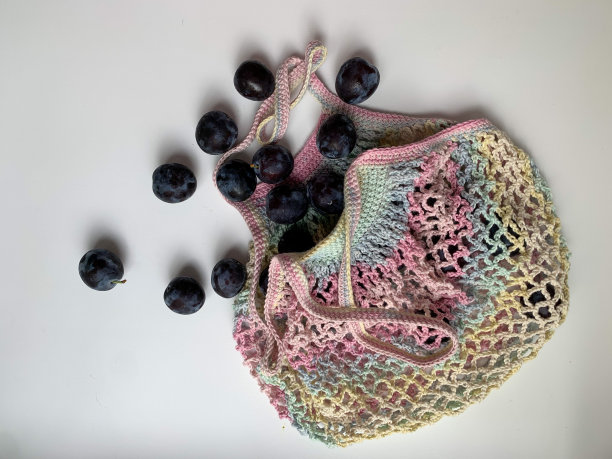 新鲜的梅子装在彩色的网袋里，背景是白色的。从上面的照片。“零浪费”。生态。爱护环境。适当的营养,素食主义图片下载