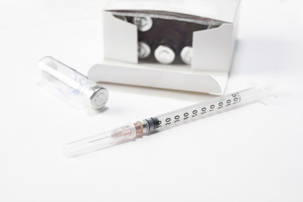 注射器针头和疫苗瓶放在白色的桌子上。预防、免疫或医学概念图片下载