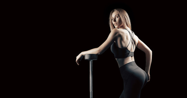 举着杠铃摆姿势的运动女孩。健身和健康生活方式概念。图片下载