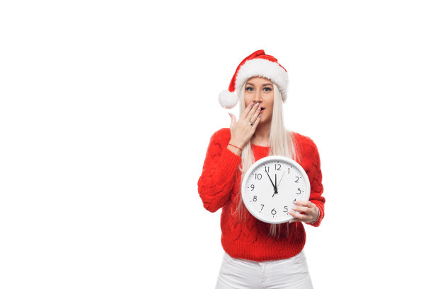 新年晚些时候和圣诞节购物的女孩带着大钟在圣诞老人的帽子上孤立的白色背景图片下载