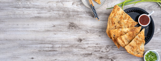 台湾美食——明亮的木桌背景上，美味的葱油饼，台湾的传统小吃，俯视图。图片下载