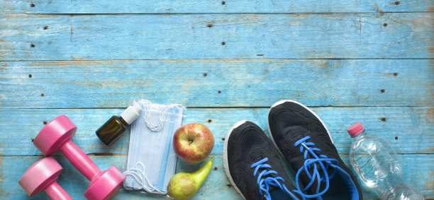 冠状病毒感染时期的体育运动;冠状病毒口罩、消毒剂喷雾、一对跑步器、哑铃、水、苹果、梨、冠状病毒政策概念图片下载