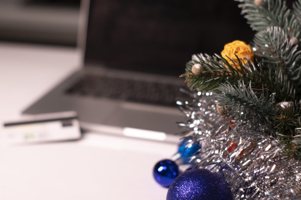 黑色屏幕和信用卡的笔记本电脑在新年装饰品附近。圣诞购物的主题。模板图片下载