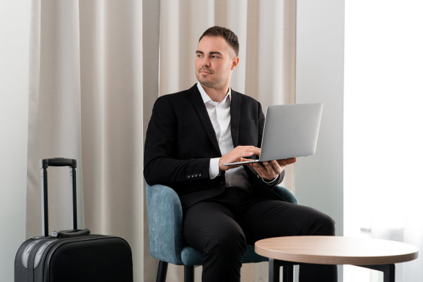 年轻的商人坐在机场的商务休息室里使用笔记本电脑图片下载