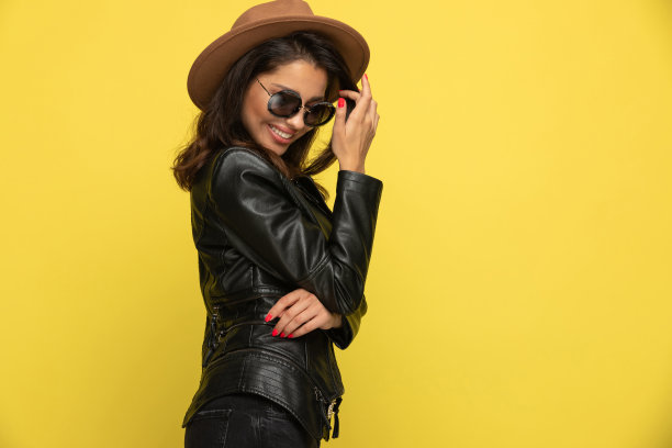 胆小的小女孩穿着皮夹克整理头发和微笑图片下载