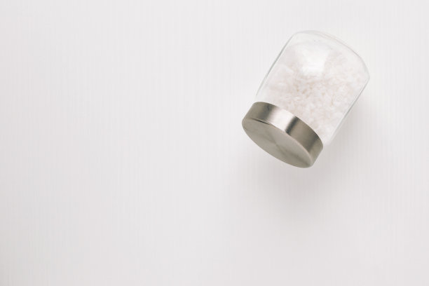 白色背景上有白色盐的玻璃罐图片下载