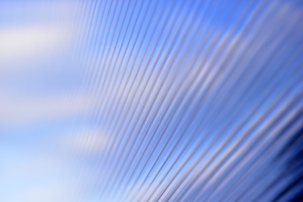 蓝色的条纹聚碳酸酯表面反射着蓝色的城市距离图片下载