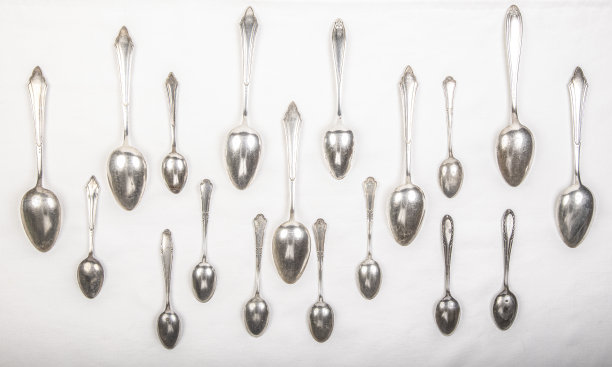 白色桌布上放着银勺，一勺又一勺，就像雨滴一样图片下载