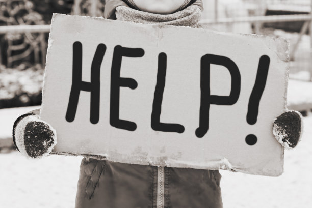 一个小孩子拿着手写的帮助标志的概念图像。有个小孩拿着手写的救命标语站着图片下载