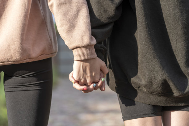 一对女孩在大街上牵手，特写图片下载