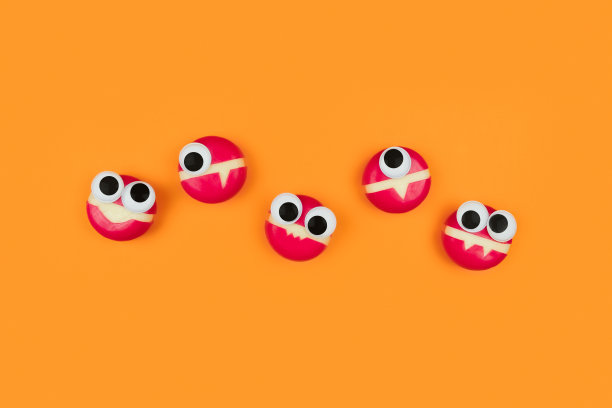 奶酪形状的小怪物，眼睛在橙色的背景。图片下载