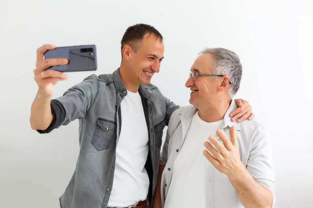 年长的父亲和成年的儿子在一个白色的背景图片下载