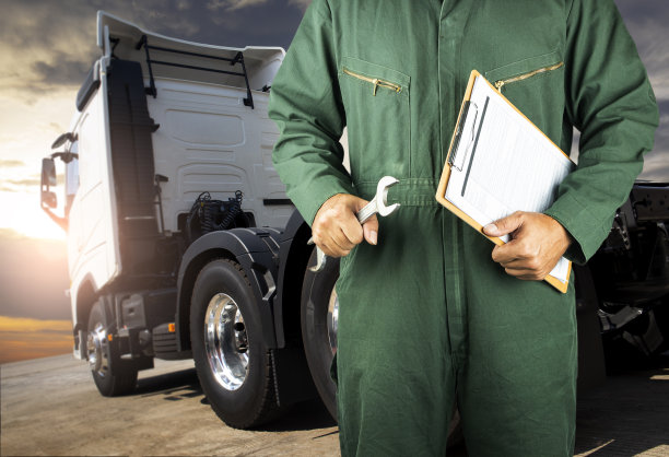 卡车的检查、维修和保养。专业的汽车修理工拿着扳手和夹板检查半卡车的维修方案。图片下载