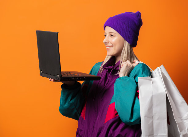 穿着90年代的运动服，带着笔记本和购物袋的时尚女士图片下载