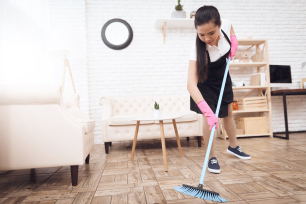 戴手套的女孩打扫房间。图片下载