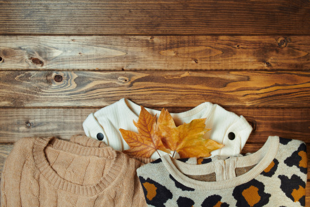 秋天的背景与毛衣和树叶的木板图片下载