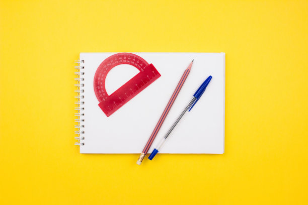 学校和办公用品平铺在五颜六色的黄色背景上。量角器，素描本，铅笔，钢笔布局俯视图。回到学校的概念。模板为网络，社交媒体。股票的照片。图片下载