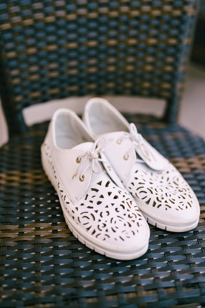 有花边和图案的女式白软皮鞋。图片下载