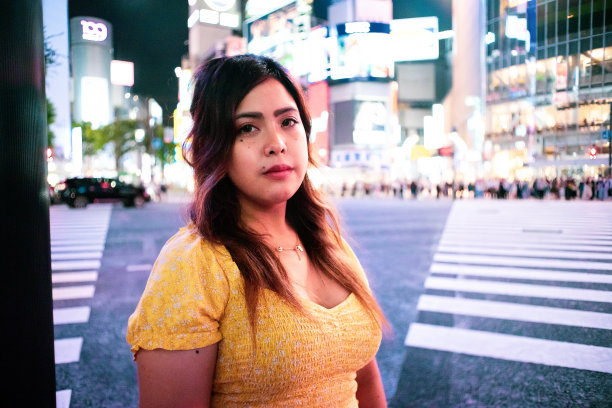 年轻女子在东京涩谷十字路口的夜景肖像图片下载
