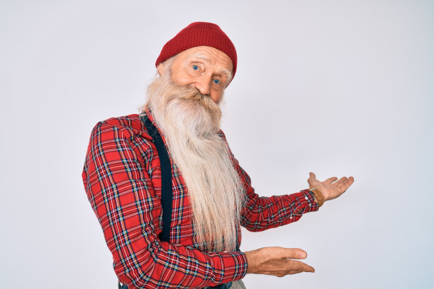 老长者，灰色头发和长胡子，穿着时髦的样子，羊毛帽邀请进入自然微笑与张开的手图片下载