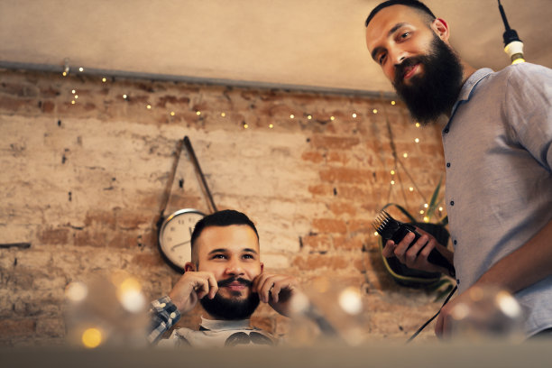 帅哥在理发店。理发师剪了他的头发，修剪了他的胡子。图片下载