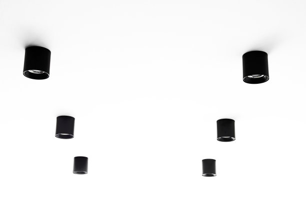 圆柱形的黑色顶灯嵌在白色的天花板上。修复的公寓图片下载