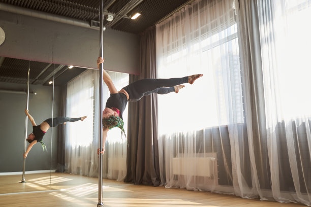 在健身课上做钢管舞硬元素运动的女人图片下载