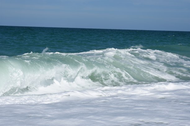 海滩上有清澈的海水和彩色的鹅卵石图片下载