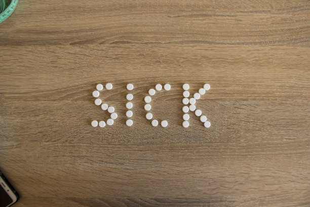 “sick”这个词被放在一张木桌上。图片下载