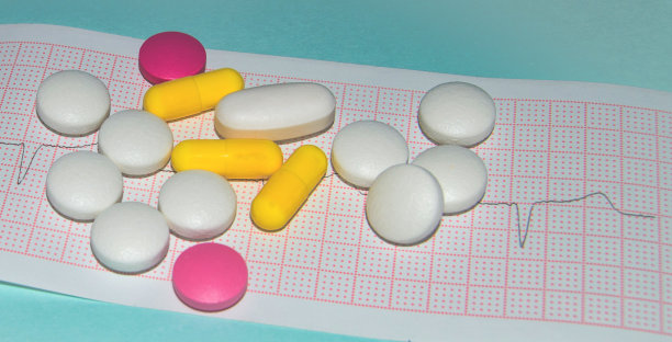 以心电图为背景口服片剂的药物。心跳如图所示，蓝色背景图片下载
