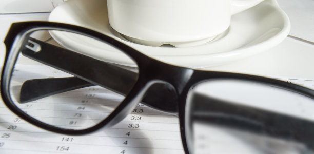 特写的黑人男子优雅的眼镜和一个白咖啡杯站在商业文件图片下载