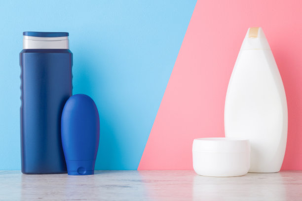 瓶，管和罐在架子上淡蓝色粉红色的墙背景。柔和的颜色。关心脸、手、腿和身体皮肤。男女美容产品。文字或标识的空白位置。前视图。图片下载