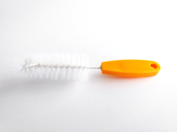 房子清洁刷工具隔离在白色背景。优雅而原汁原味的橙色餐具清洁刷。关闭厨房用具清洗盘子。图片下载